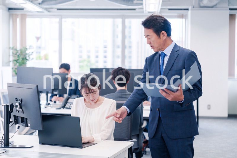 オフィスで上司から叱責をされる若い女性社員