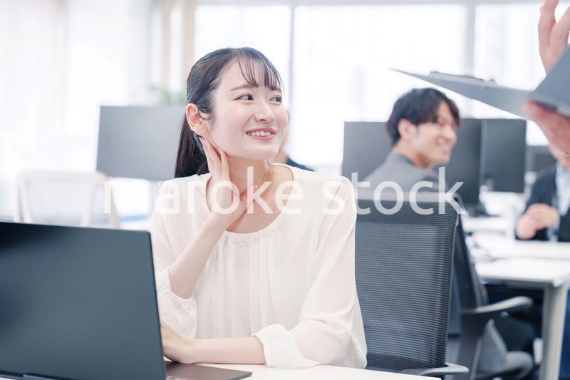 オフィスで楽しく雑談をする若い女性