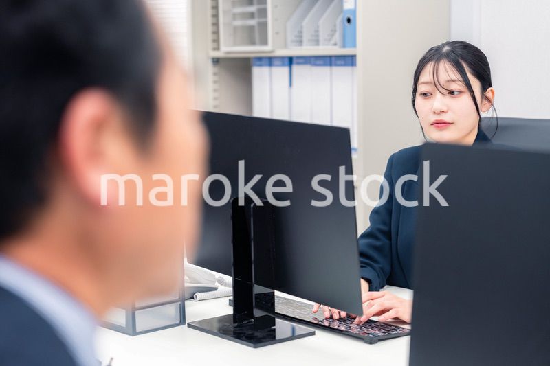 オフィスで生き生きとデスクワークをする若い女性