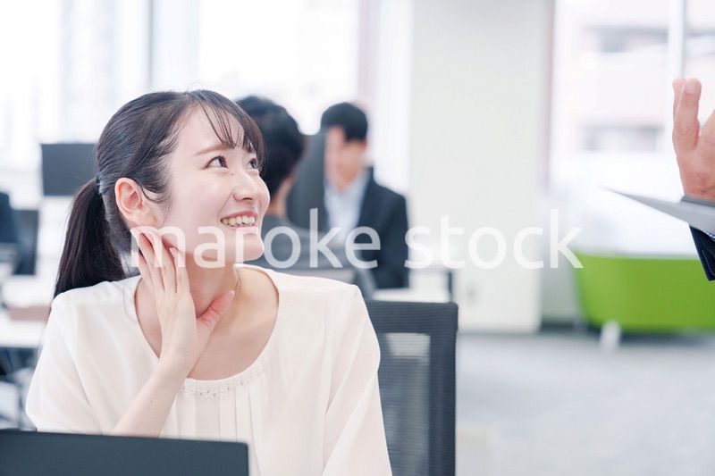 オフィスで楽しく雑談をする若い女性