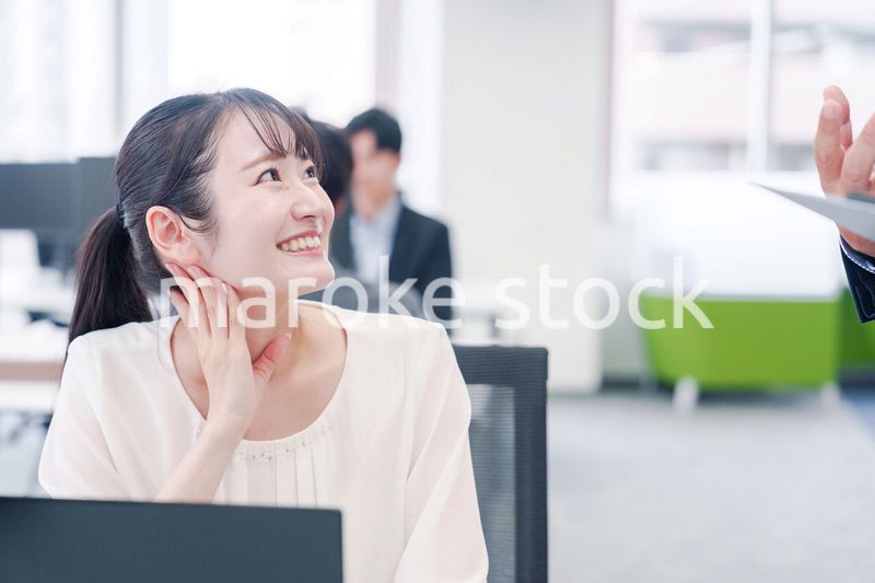 オフィスで楽しく雑談をする若い女性