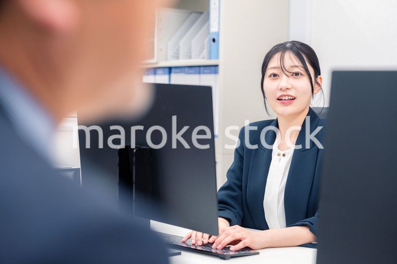 オフィスで生き生きとデスクワークをする若い女性