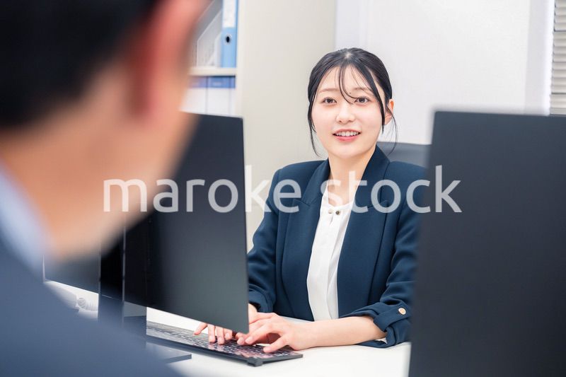 オフィスで生き生きとデスクワークをする若い女性