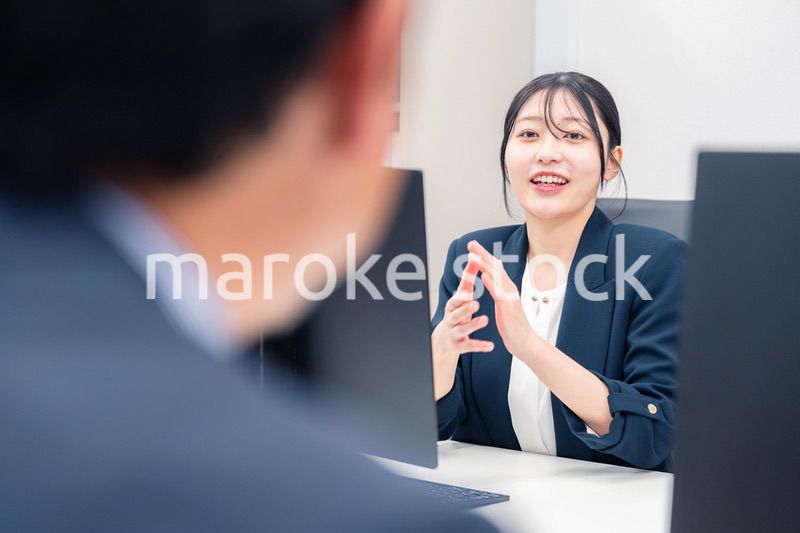 オフィスで生き生きとデスクワークをする若い女性