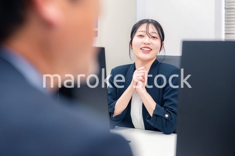 オフィスで生き生きとデスクワークをする若い女性