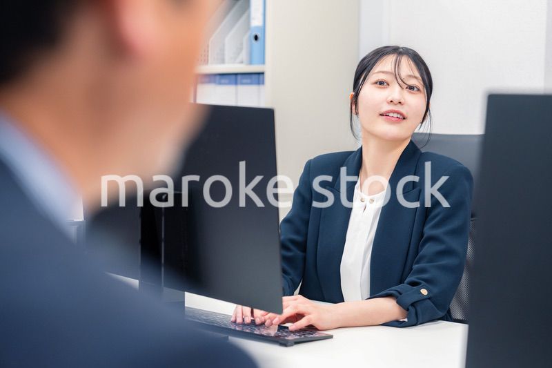 オフィスで生き生きとデスクワークをする若い女性