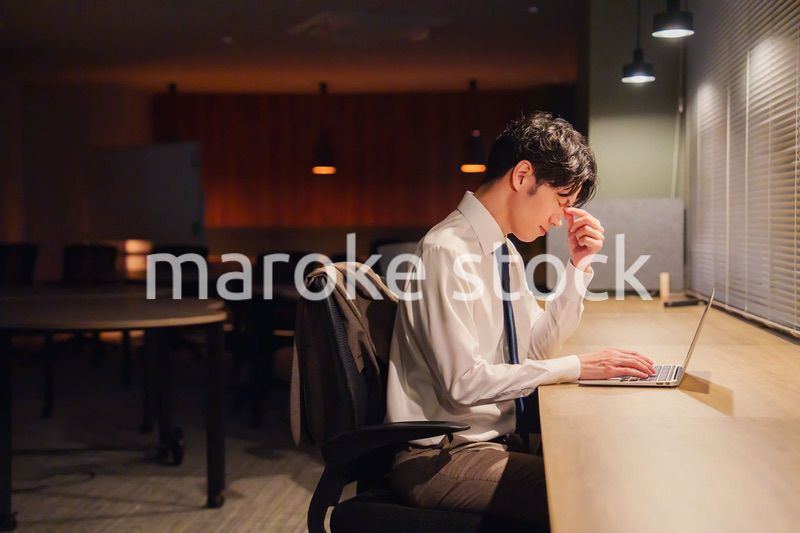 夜遅くまで残業をする若い男性スタッフ