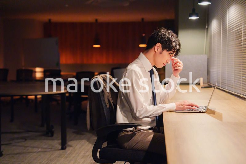 夜遅くまで残業をする若い男性スタッフ