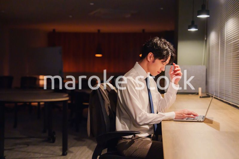 夜遅くまで残業をする若い男性スタッフ