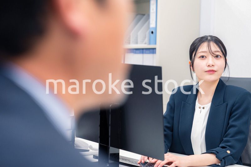 オフィスで生き生きとデスクワークをする若い女性