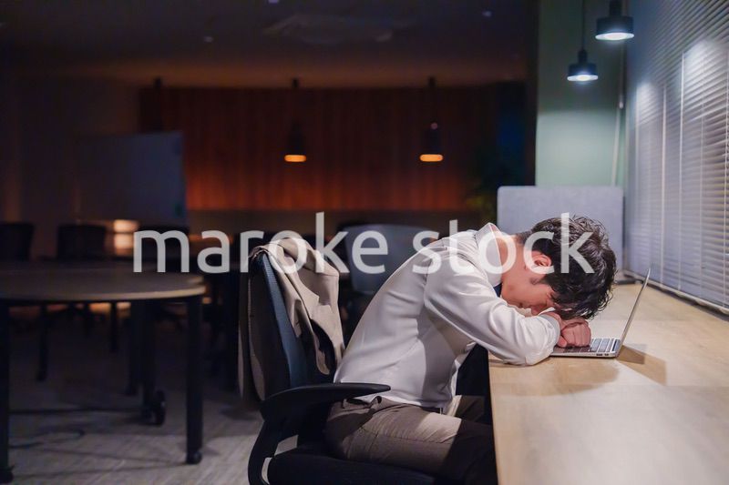 夜遅くまで仕事をしてオフィスで寝落ちをしてしまう男性