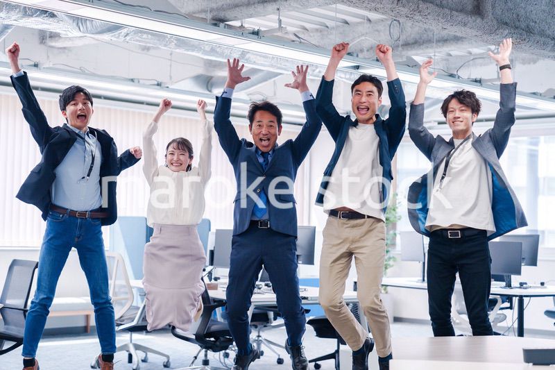 オフィスで大喜びをしてジャンプをするビジネスパーソン