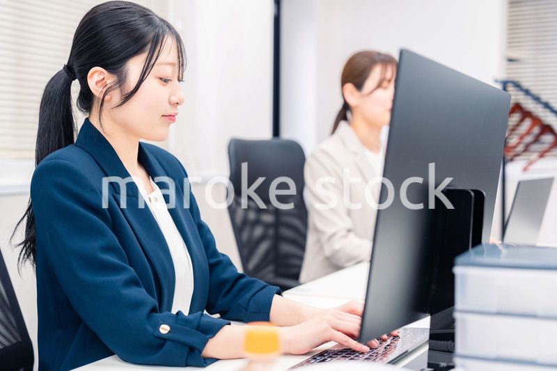 オフィスでデスクワークをする若い女性