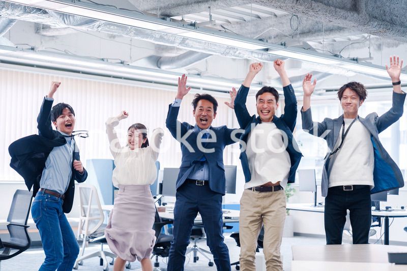 オフィスで大喜びをしてジャンプをするビジネスパーソン