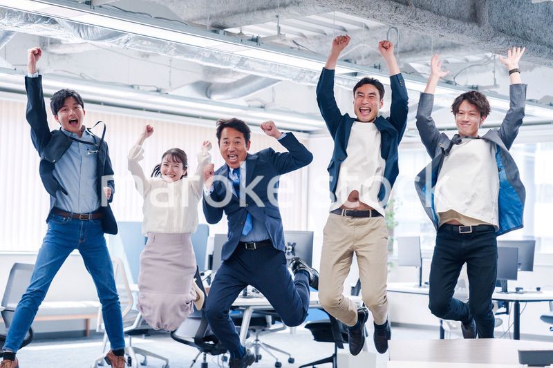 オフィスで大喜びをしてジャンプをするビジネスパーソン