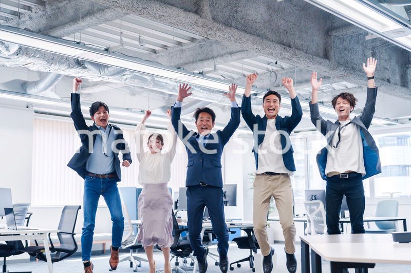 オフィスで大喜びをしてジャンプをするビジネスパーソン