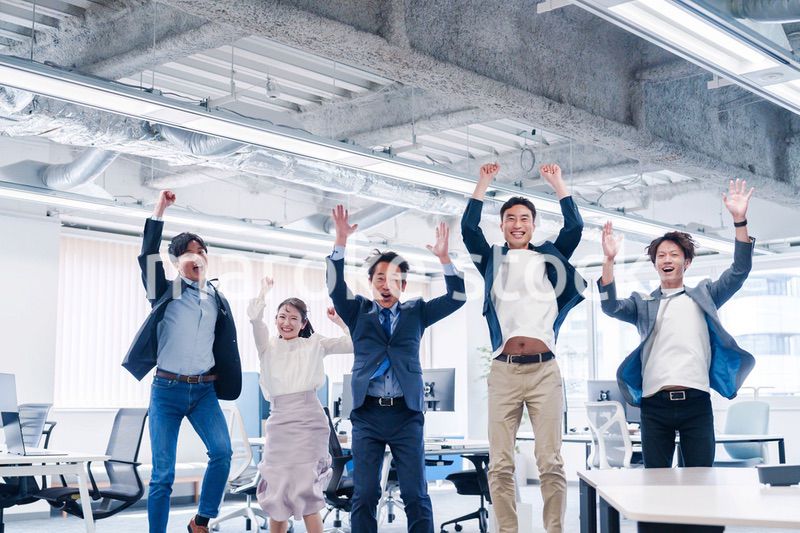 オフィスで大喜びをしてジャンプをするビジネスパーソン