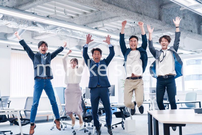 オフィスで大喜びをしてジャンプをするビジネスパーソン