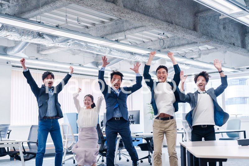 オフィスで大喜びをしてジャンプをするビジネスパーソン