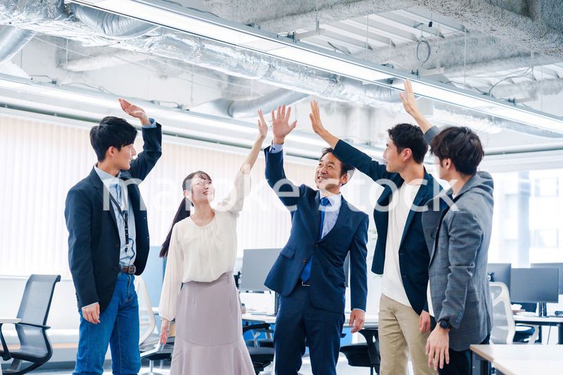 オフィスでハイタッチをするビジネスパーソン
