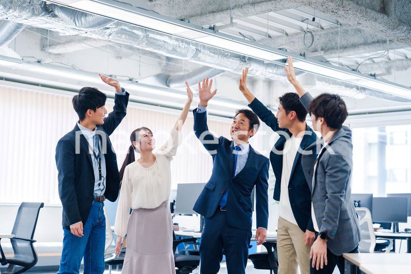 オフィスでハイタッチをするビジネスパーソン
