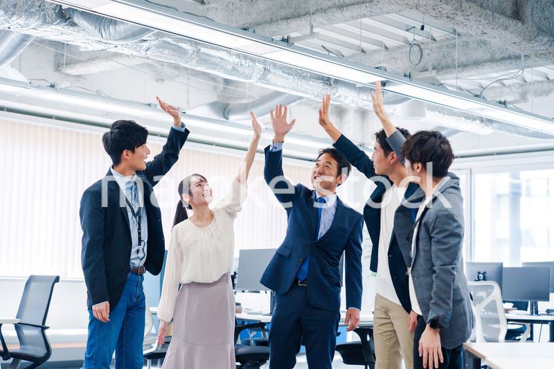 オフィスでハイタッチをするビジネスパーソン