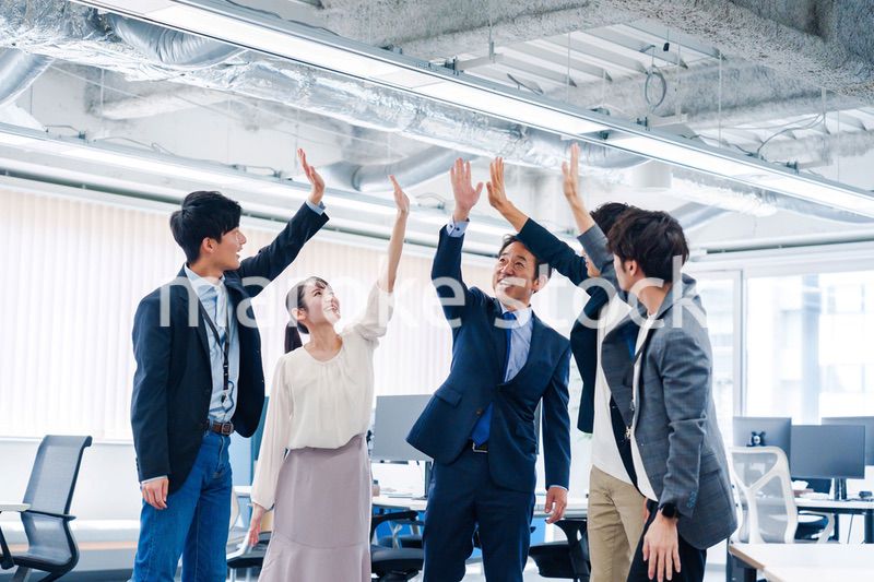 オフィスでハイタッチをするビジネスパーソン