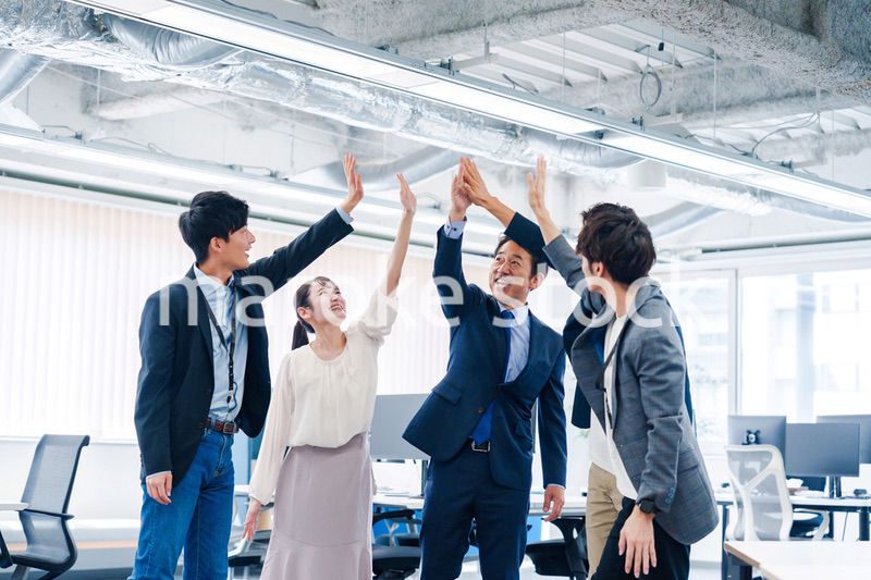 オフィスでハイタッチをするビジネスパーソン