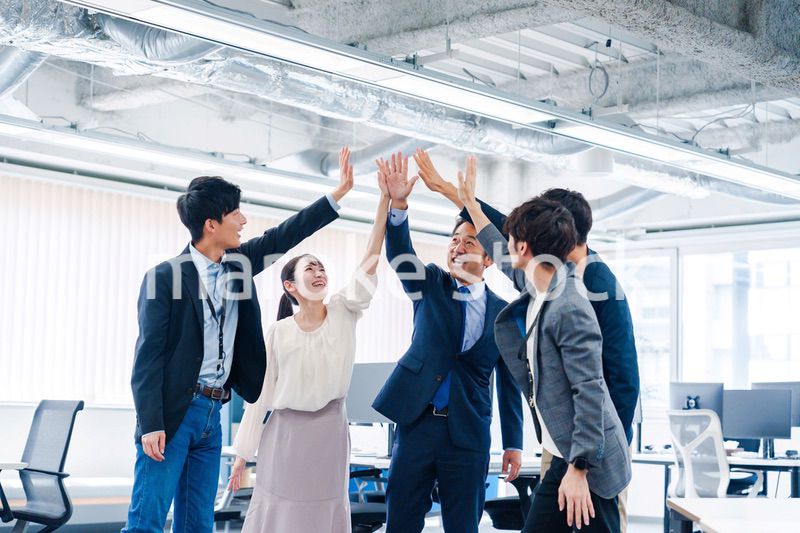 オフィスでハイタッチをするビジネスパーソン