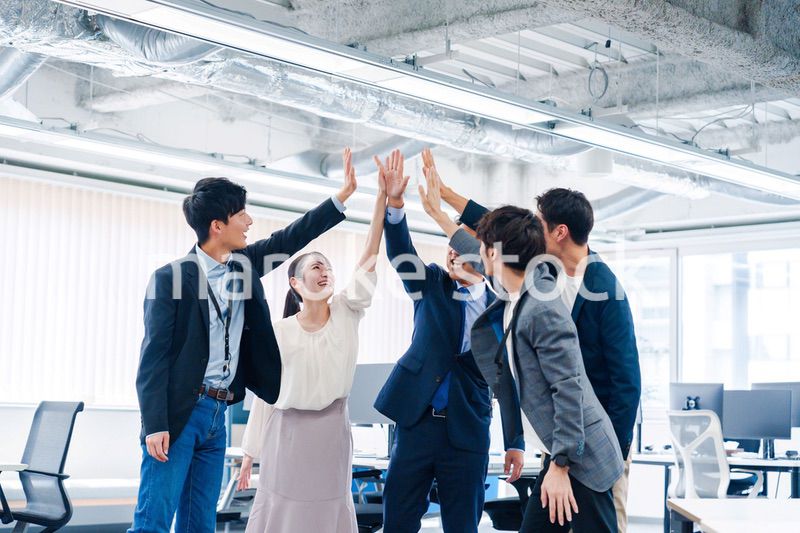 オフィスでハイタッチをするビジネスパーソン