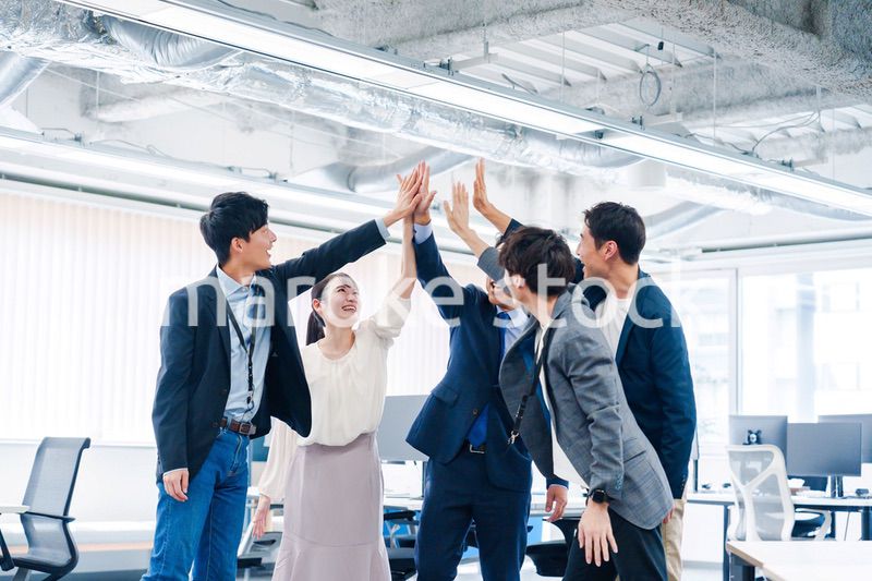 オフィスでハイタッチをするビジネスパーソン