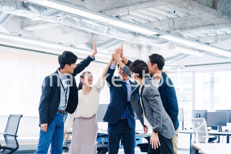 オフィスでハイタッチをするビジネスパーソン