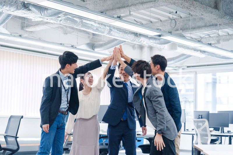 オフィスでハイタッチをするビジネスパーソン