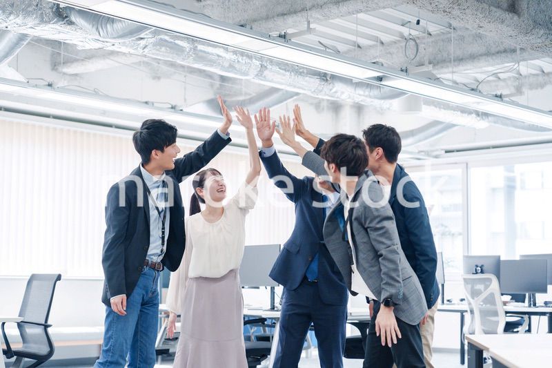 オフィスでハイタッチをするビジネスパーソン