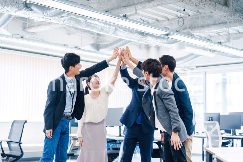 オフィスでハイタッチをするビジネスパーソン