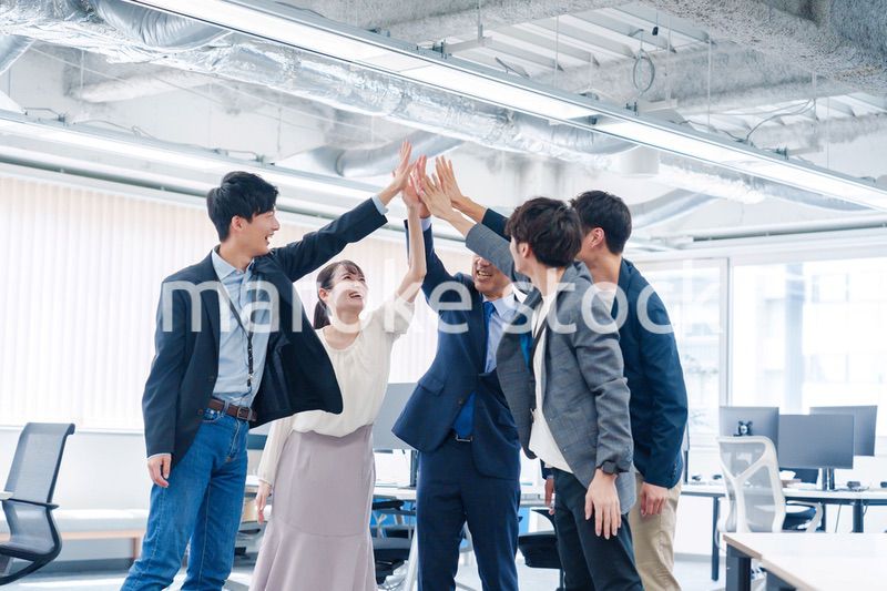 オフィスでハイタッチをするビジネスパーソン