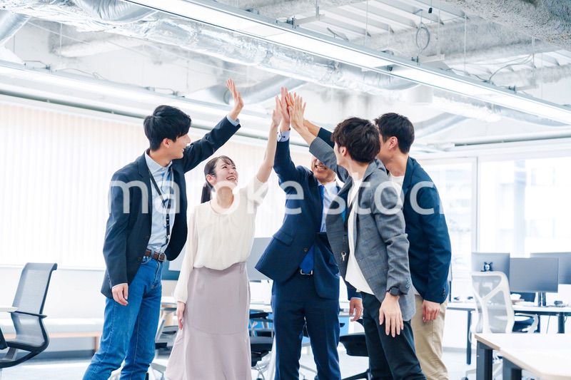 オフィスでハイタッチをするビジネスパーソン