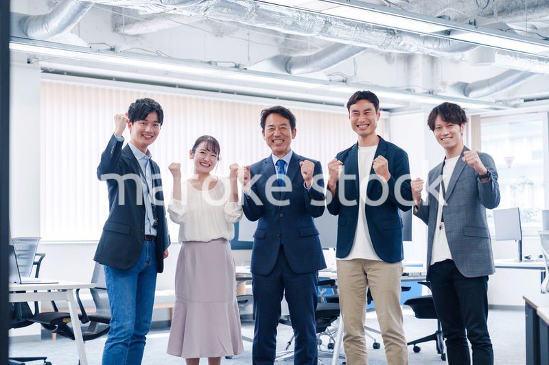 オフィスで笑顔でガッツポーズをするビジネスパーソン
