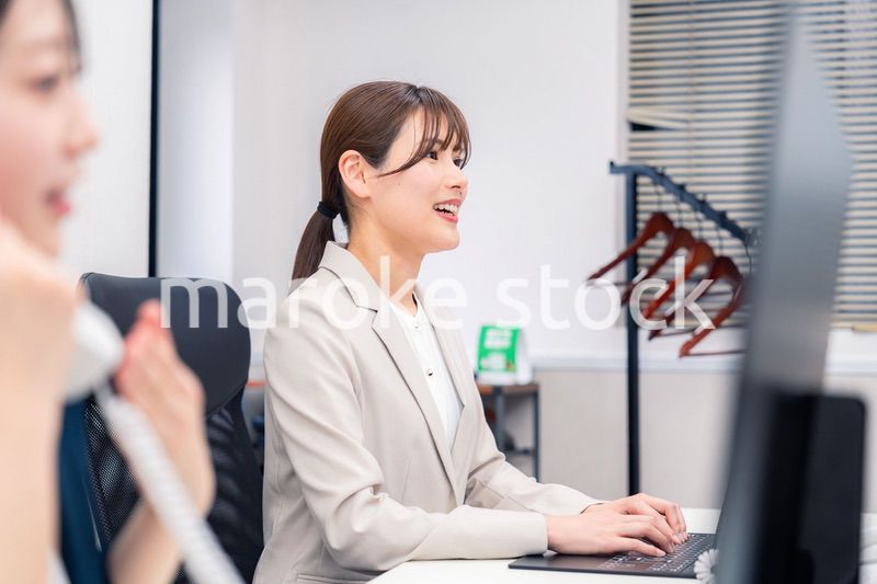 オフィスで事務の仕事をする若い女性社員