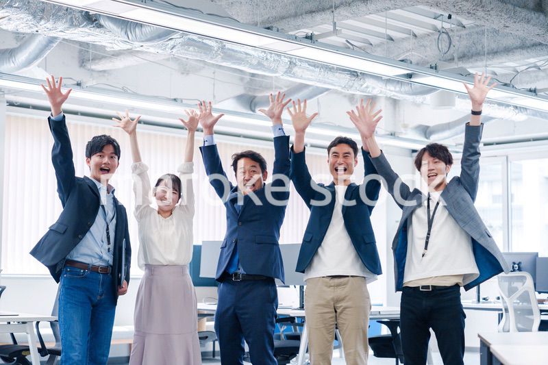 オフィスで大喜びをしてジャンプをするビジネスパーソン