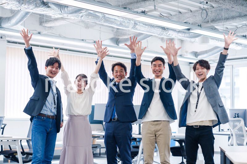 オフィスで大喜びをしてジャンプをするビジネスパーソン