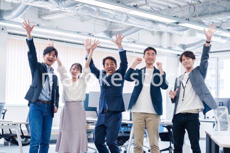 オフィスで大喜びをしてジャンプをするビジネスパーソン