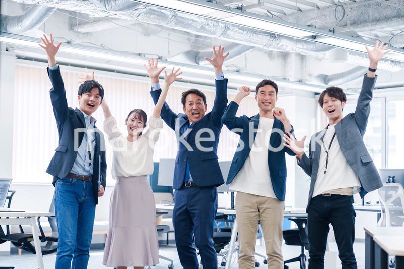 オフィスで大喜びをしてジャンプをするビジネスパーソン