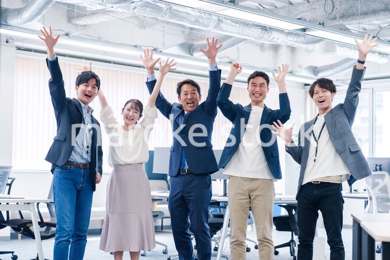 オフィスで大喜びをしてジャンプをするビジネスパーソン