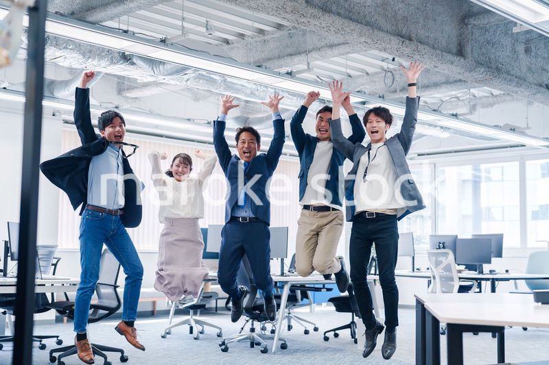 オフィスで大喜びをしてジャンプをするビジネスパーソン
