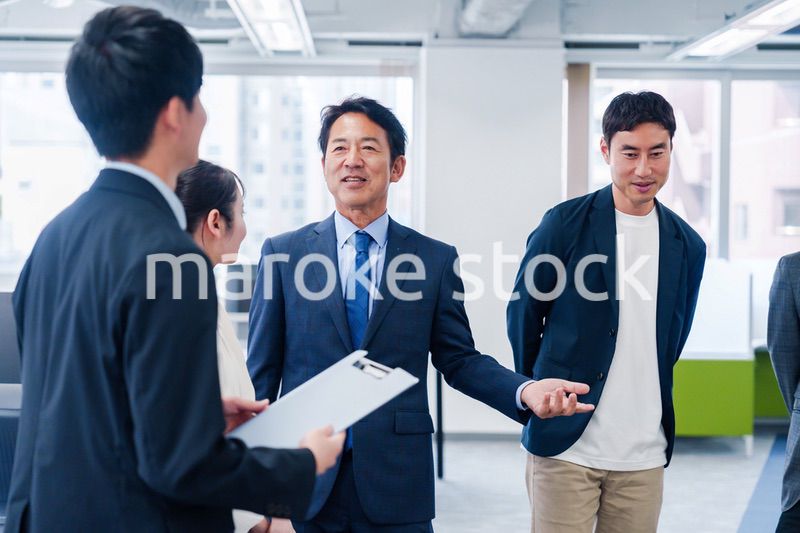 オフィスで立ち話をするビジネスパーソン