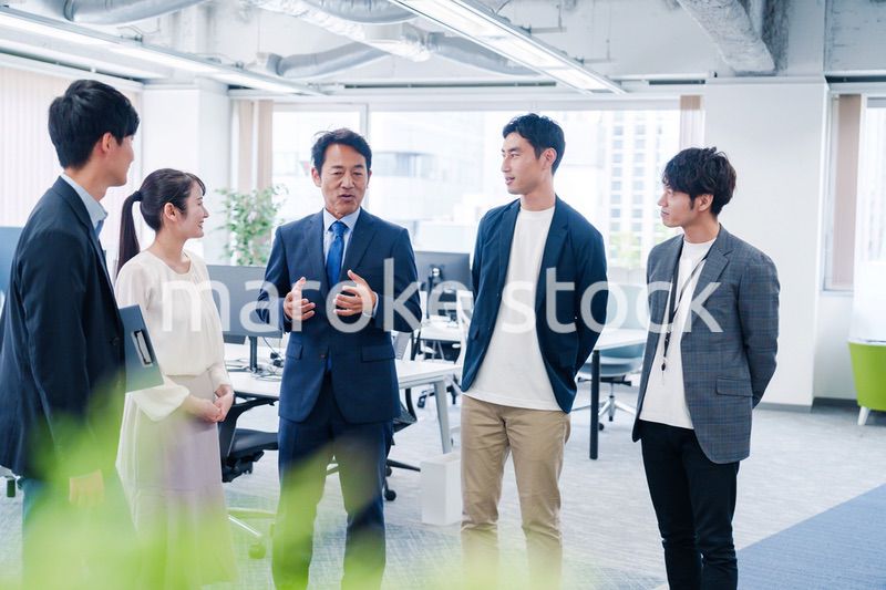 オフィスで立ち話をするビジネスパーソン