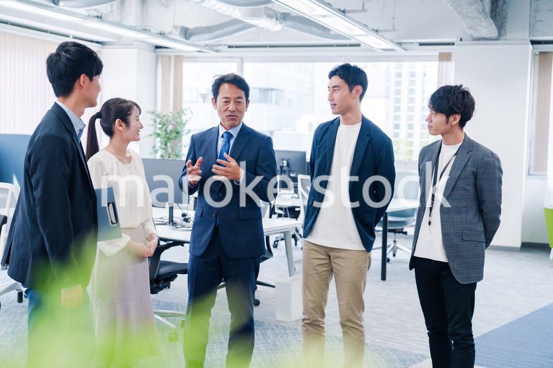 オフィスで立ち話をするビジネスパーソン