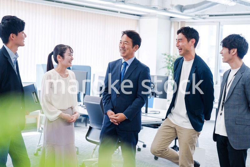 オフィスで立ち話をするビジネスパーソン