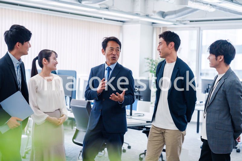 オフィスで立ち話をするビジネスパーソン